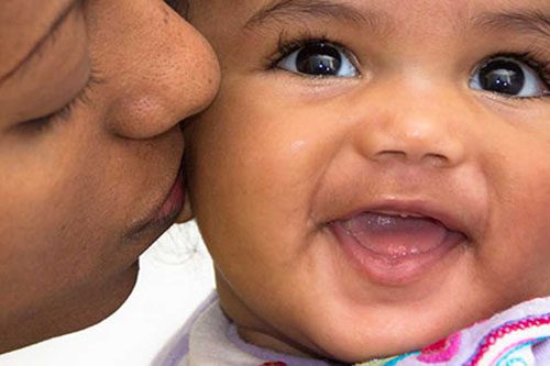 A smiling baby during a pediatric eye exam