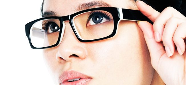 A woman adjusting her eyeglasses